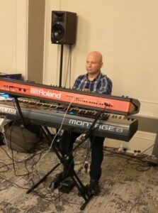 Henric plays the keyboard at the Continued Care Christmas Party